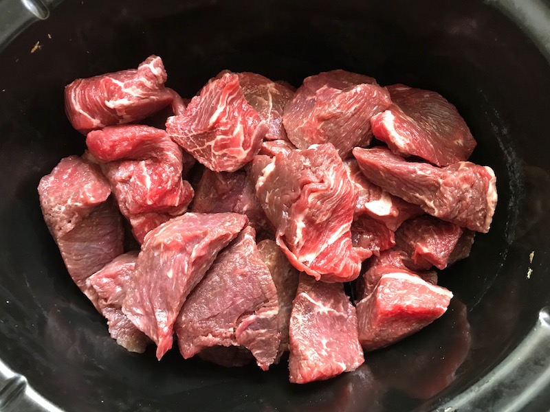 Raw beef cubes in pot for Shredded Beef Ragu Recipe with Pappardelle. It's so easy to make and has a thick meaty texture and a super rich delicious flavor.