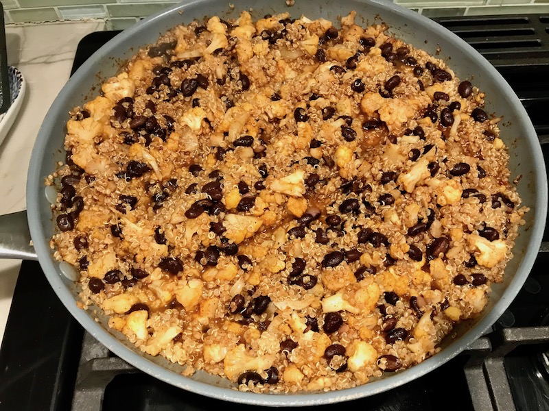 Quinoa, Black beans and Cauliflower florets in pan for Quinoa Black Bean Burritos. Packed with protein and fiber, but also cheese, tomato, cilantro, and sour cream! The vegetarian 'meat' is taco-seasoned quinoa, black beans, and cauliflower.
