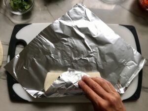 Wrapping in foil, Quinoa Black Bean Burrito. Packed with protein and fiber, but also cheese, tomato, cilantro, and sour cream! The vegetarian 'meat' is taco-seasoned quinoa, black beans, and cauliflower.