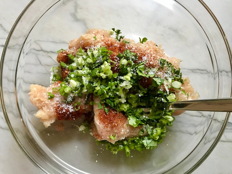 Scallions, seasonings, cilantro, and raw ground chicken in a bowl before mixing for Chicken or Turkey Taco Burger Recipe.