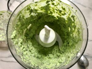 Basil, chives, spinach, and sour cream blended in food processor for Green Rice Recipe. It takes white rice from plain to amazing with just 5 ingredients. Filled with herbs and spinach, it has the perfect herby flavor.