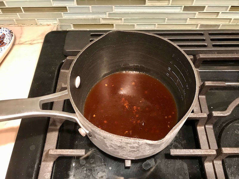 Sweet and sour sauce in a small pot on stove for Sweet and Sour sauce Chicken Kabobs with pineapple, onion, and red pepper.