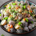 Harissa Potato Salad Recipe with Edamame and Harissa in a bowl on table. It's creamy, crunchy, meaty, tangy, peppery, salty, and oh, it's UNBELIEVABLE!