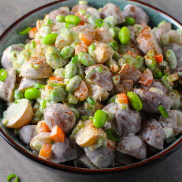 Harissa Potato Salad Recipe with Edamame and Harissa in a bowl on table. It's creamy, crunchy, meaty, tangy, peppery, salty, and oh, it's UNBELIEVABLE!