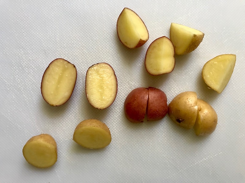 Cut raw red potatoes for Red Potato Salad Recipe with Edamame and Harissa. It's creamy, crunchy, meaty, tangy, peppery, salty, and oh, it's UNBELIEVABLE!