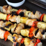 Sweet and Sour Chicken Kabobs with pineapple, onion, and red pepper on a pan.
