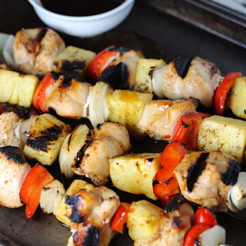 Sweet and Sour Chicken Kabobs with pineapple, onion, and red pepper on a pan.