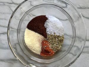 Five spices sectioned in a bowl for Creamy Corn and Blackened Chicken skillet dinner