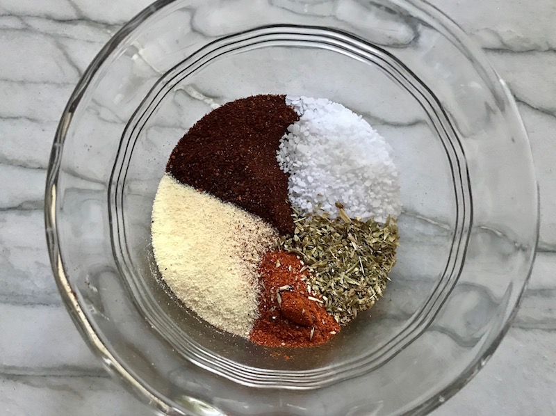 Five spices sectioned in a bowl for Creamy Corn and Blackened Chicken skillet dinner