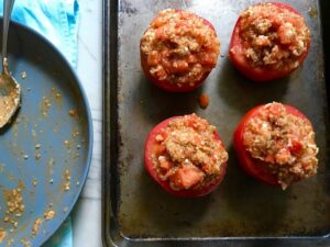 4 Stuffed Tomatoes on sheet pan with chorizo, quinoa, parmesan cheese, chives, garlic, and oregano.