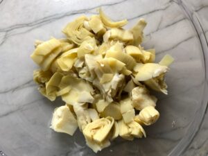 Cut artichoke hearts for Chicken Artichoke Bake with Tomatoes and Goat Cheese. It's a creamy, tangy, sweet, savory, mouth watering easy dinner that you can prep ahead!