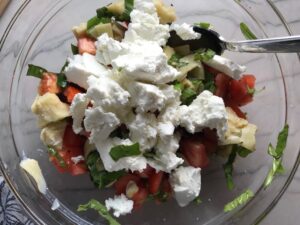 goat cheese, cut artichoke hearts, tomatoes, and basil in bowl for Chicken Artichoke Bake with Tomatoes and Goat Cheese. It's a creamy, tangy, sweet, savory, mouth watering easy dinner that you can prep ahead!