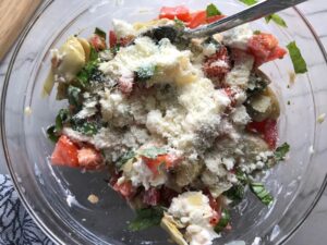 Ingredients in bowl for Chicken Artichoke Bake with Tomatoes and Goat Cheese. It's a creamy, tangy, sweet, savory, mouth watering easy dinner that you can prep ahead!