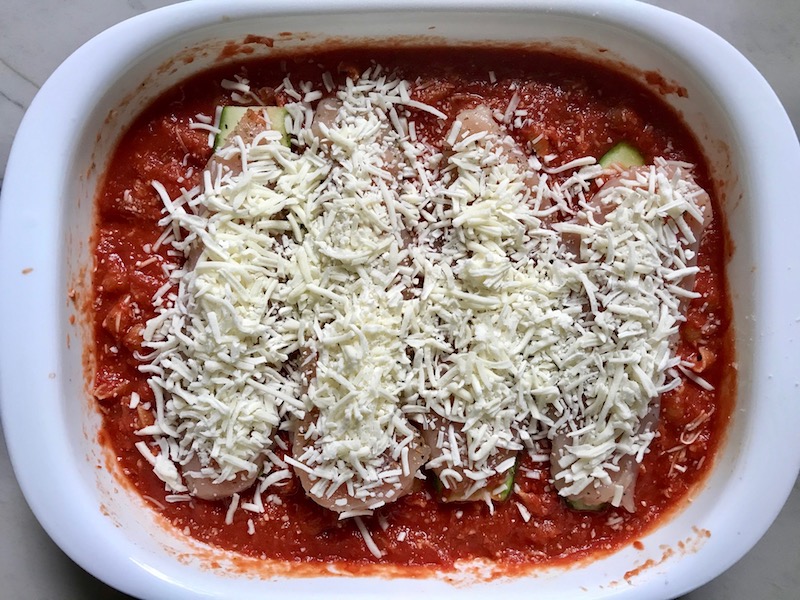 Chicken Parmesan Pasta Bake in casserole pan. It cooks entirely in one casserole dish, including the pasta! Shell pasta in flavorful, tangy tomato sauce is topped with zucchini, chicken, mozzarella, parm, and crunchy breadcrumb topping.