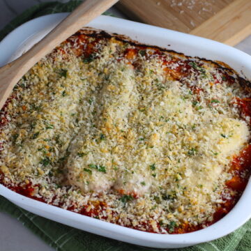 Chicken Parmesan Pasta Bake in casserole pan. It cooks entirely in one casserole dish, including the pasta! Shell pasta in flavorful, tangy tomato sauce is topped with zucchini, chicken, mozzarella, parm, and crunchy breadcrumb topping.