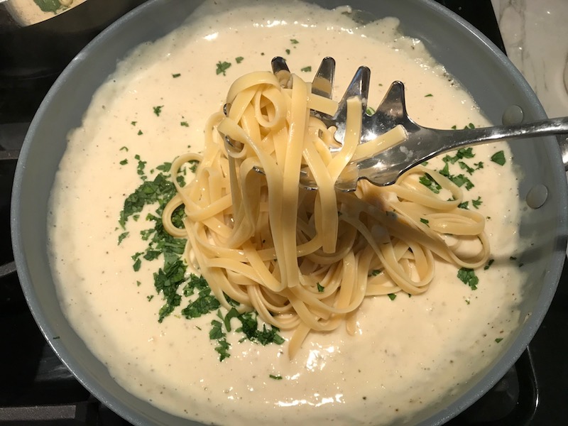 Adding cooked pasta to sauce in pan for Light and Easy Fettuccine Alfredo with Prosciutto