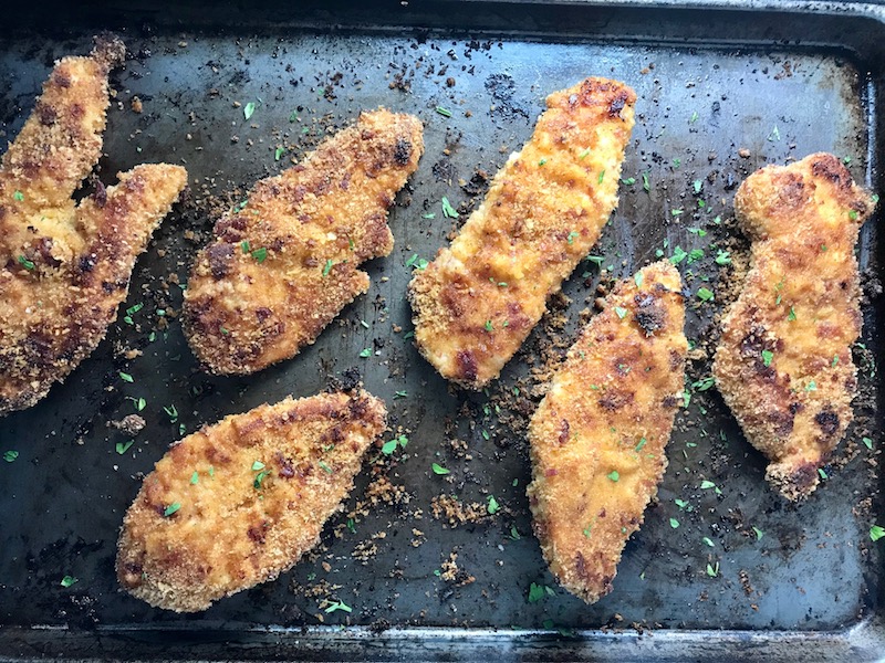 Oven Fried Chicken Breast on pan. The chicken is coated with Bacon Crumbs and Honey and it's healthier because it's baked, not fried, but still gives you all of the crispy, crunchy goodness! It also gives you sweet and salty crunch with the addition of honey and bacon!