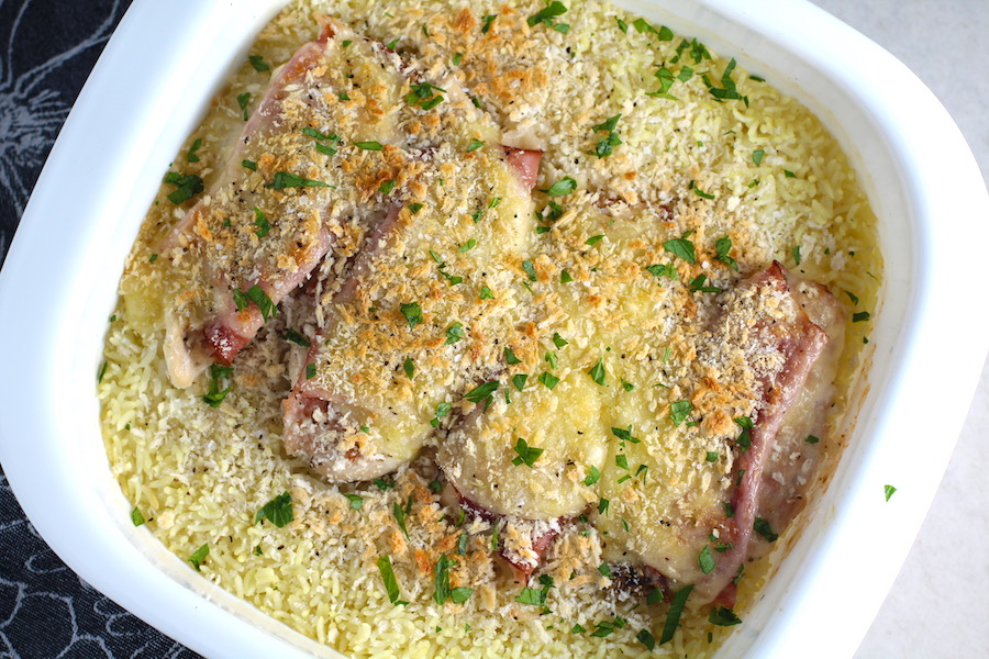 Chicken Cordon Bleu and Rice Casserole in casserole dish. On the bottom you get flavorful rice topped with chicken, salty ham, nutty and melty swiss cheese, and a crunchy breadcrumb topping!
