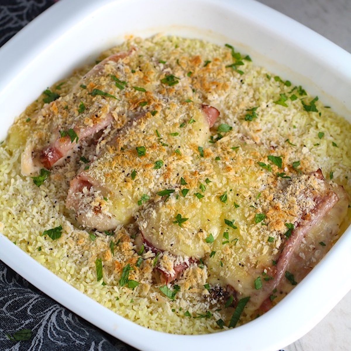 Chicken Cordon Bleu Rice Bake in casserole dish. On the bottom you get flavorful rice topped with chicken, salty ham, nutty and melty swiss cheese, and a crunchy breadcrumb topping!