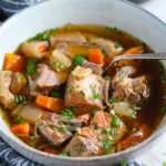 Paprika Pork Stew Recipe in a bowl with carrots, onion, parsley. It's an easy family dinner. 