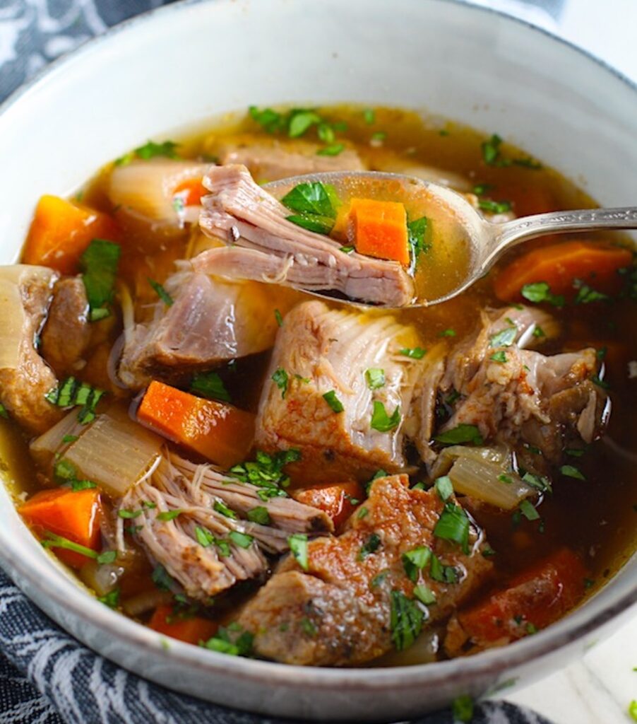 Paprika Pork Stew Recipe in a bowl with carrots, onion, parsley. It's an easy family dinner.