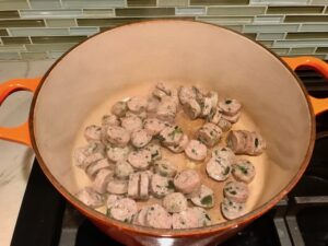 Sausage slices in pot for Creamy Chicken Sausage and Tortellini Soup. It's silky and creamy with onions, garlic, Chicken sausage, and zucchini bring so much flavor and texture. The tortellini give that delicious salty, creamy, hearty bite!