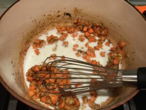Milk added to roux and carrots in pot for Creamy Chicken Sausage and Tortellini Soup. It's silky and creamy with onions, garlic, Chicken sausage, and zucchini bring so much flavor and texture. The tortellini give that delicious salty, creamy, hearty bite!