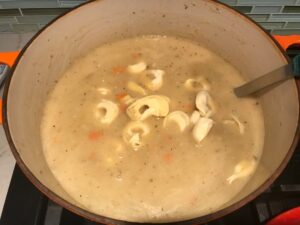 Tortellini added to soup in pot for Creamy Chicken Sausage and Tortellini Soup. It's silky and creamy with onions, garlic, Chicken sausage, and zucchini bring so much flavor and texture. The tortellini give that delicious salty, creamy, hearty bite!