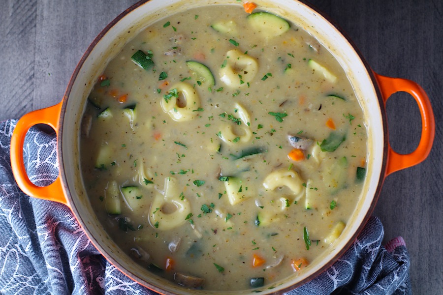 Creamy Chicken Sausage and Tortellini Soup in a large pot on table. It's silky and creamy with onions, garlic, Chicken sausage, and zucchini bring so much flavor and texture. The tortellini give that delicious salty, creamy, hearty bite!