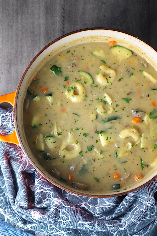 Creamy Chicken Sausage and Tortellini Soup in a large pot on table. It's silky and creamy with onions, garlic, Chicken sausage, and zucchini bring so much flavor and texture. The tortellini give that delicious salty, creamy, hearty bite!