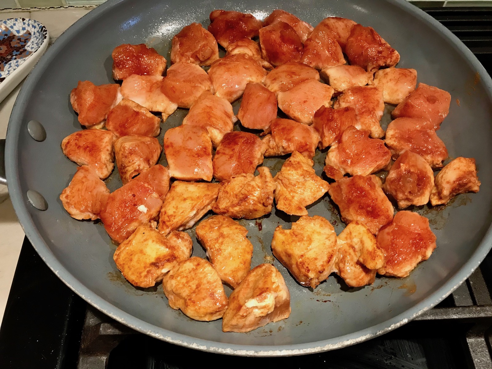 Cubed chicken seasoned with paprika in a frying pan for Quick Cooking Creamy Paprika Chicken. It's creamy, smokey, rich, and hearty. This is an easy weeknight family dinner!