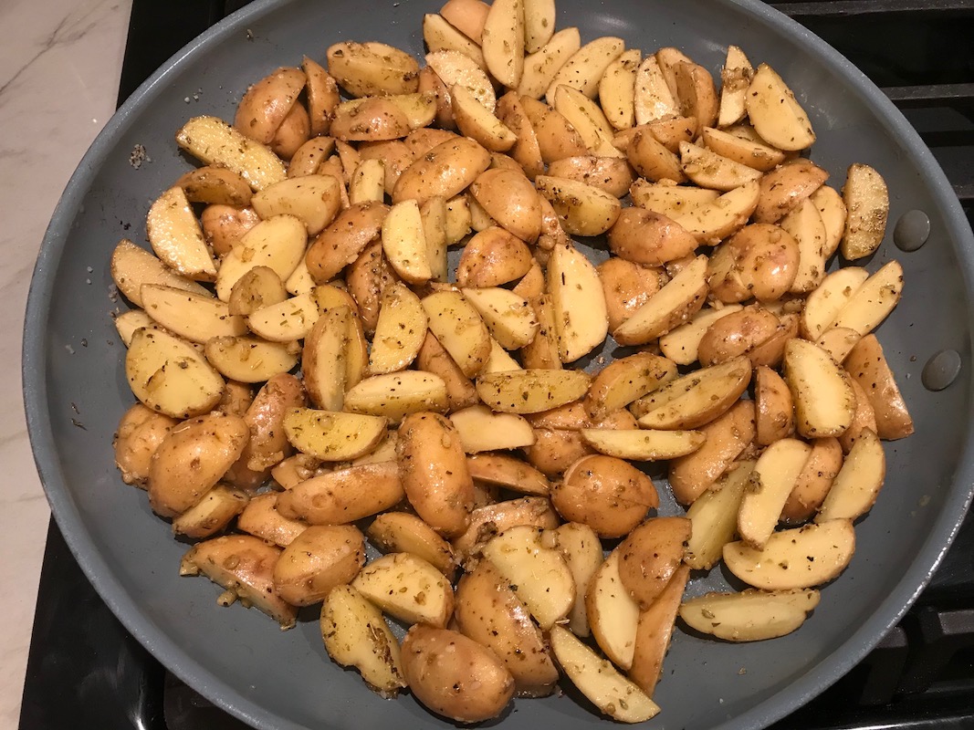 Potatoes cooking in a pan for Garlic Potato and Steak Bites Recipe. It's an easy and delicious, one-pan family dinner! You get fantastic salty, buttery, tender steak and potatoes in each and every mouthwatering bite!