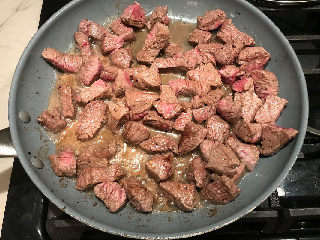 Steak bites cooking in a pan for Garlic Potato and Steak Bites Recipe. It's an easy and delicious, one-pan family dinner! You get fantastic salty, buttery, tender steak and potatoes in each and every mouthwatering bite!
