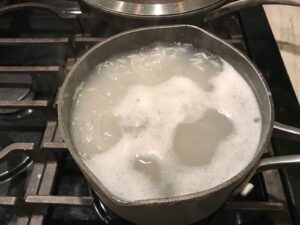 Boiling rice in pot for Saffron Butter Crispy Rice. Saffron brings a floral note and beautiful yellow-orange color. Added to the butter is what gives this crispy rice the buttery, crispy bottom.