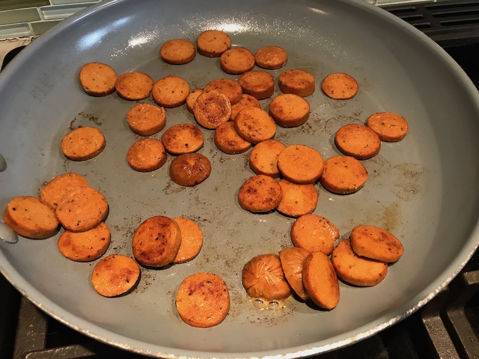 Andouille sausage slices cooking in a pan for Shrimp and Grits recipe.