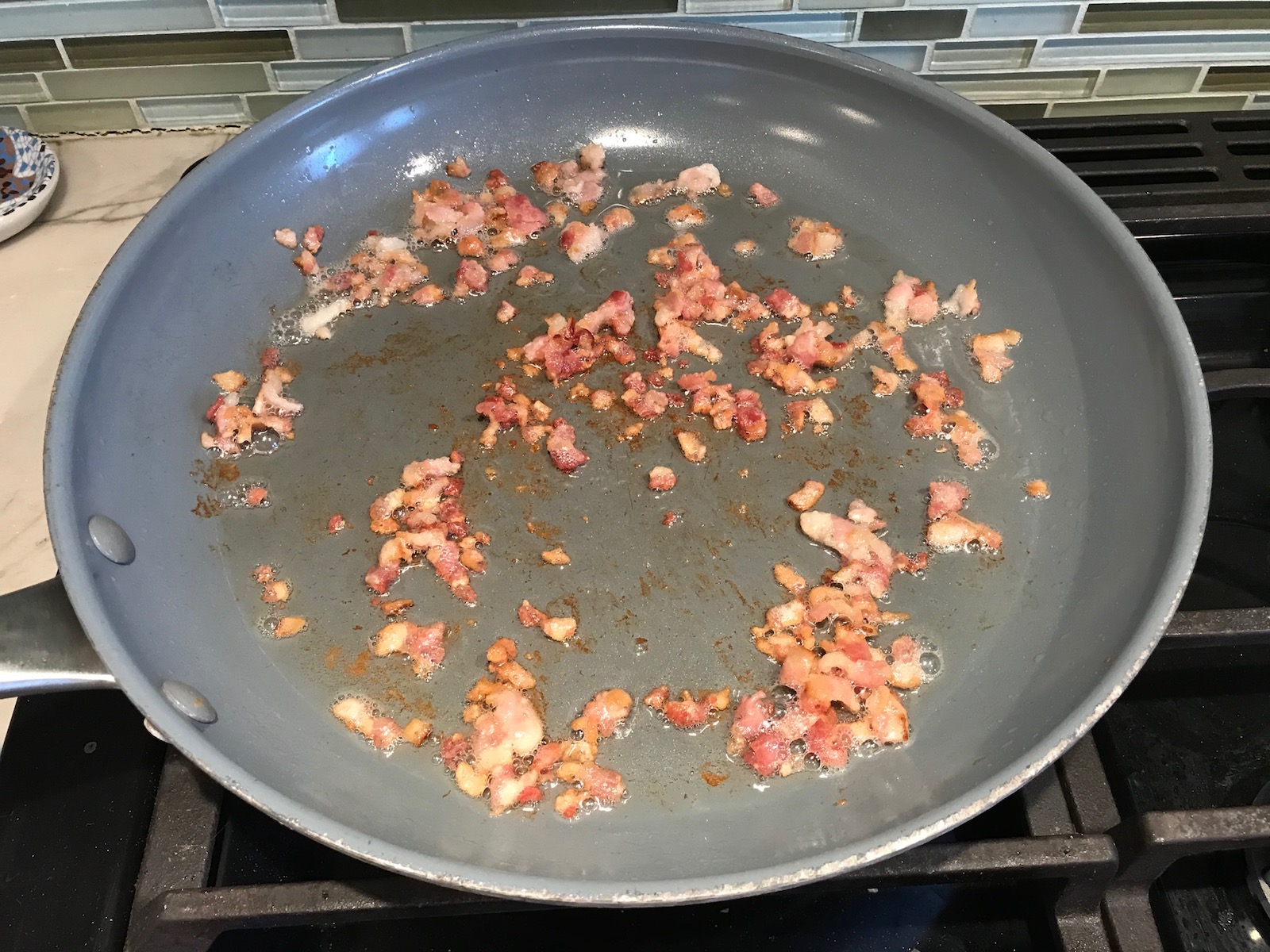 Bacon bits cooking in pan for Ricotta Sauce Pasta with Bacon and Mushroom Sauce on stove. It's creamy, rich, decadent, comforting, and downright delicious!