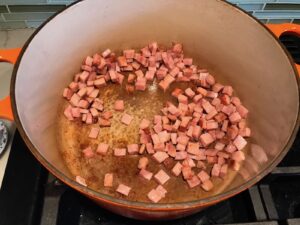 Diced ham cooking in pot for Golden Carrot Ginger Soup Recipe.