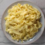 Easy Homemade Pasta, plain Fettuccine, on a plate on counter.