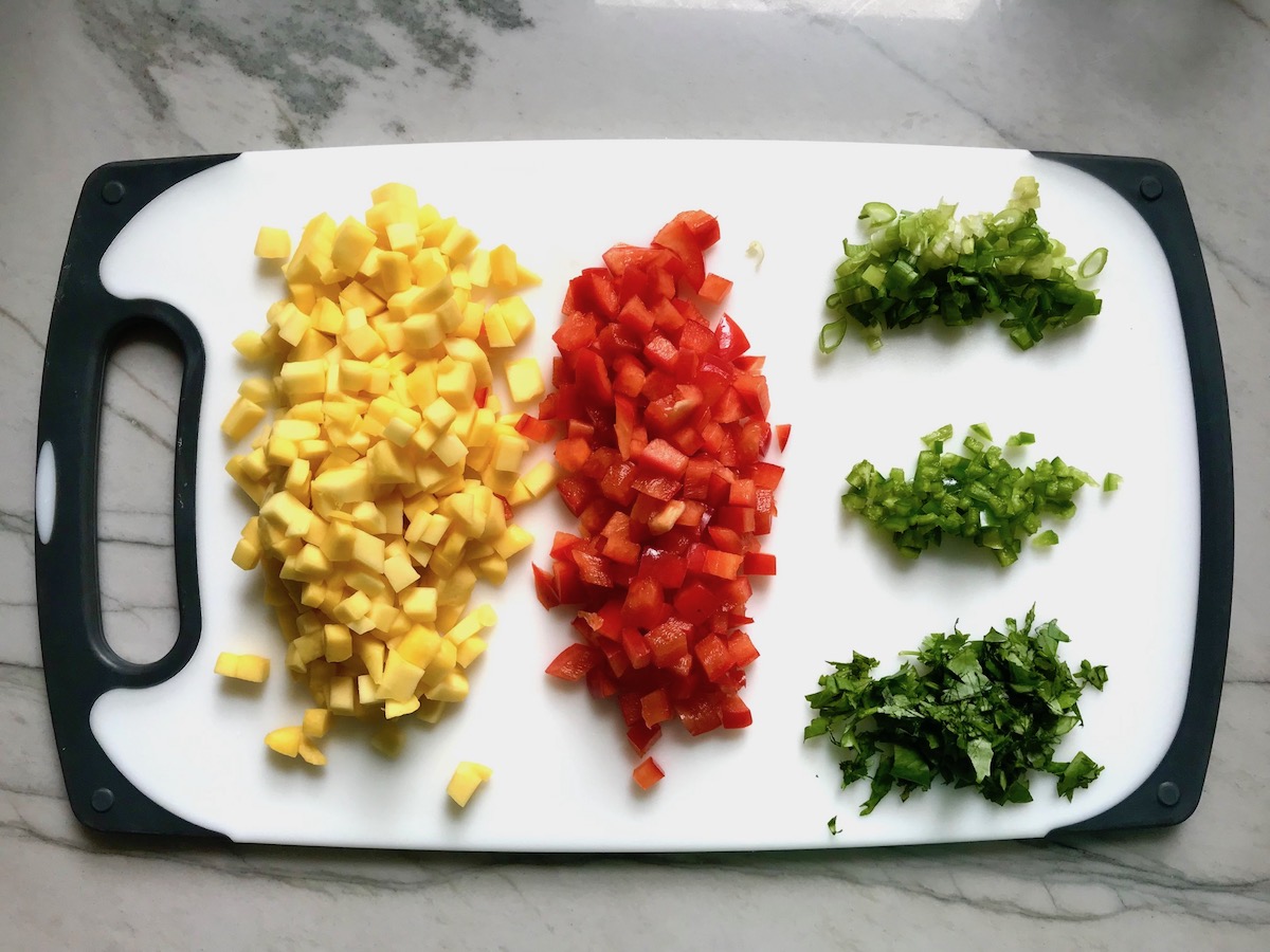 Diced mango, red pepper, scallions, jalapeno, and cilantro on cutting board for Grilled Shrimp Tacos