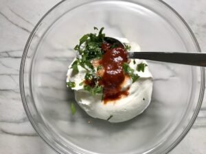 Sour Cream, cilantro, and chipotle in adobo in a bowl for for Grilled Shrimp Tacos