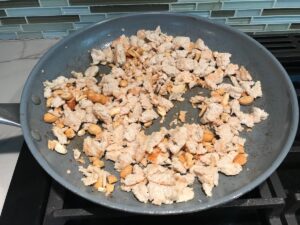 Ground chicken cooking in a pan for this Cashew Chicken Lettuce Wrap Recipe