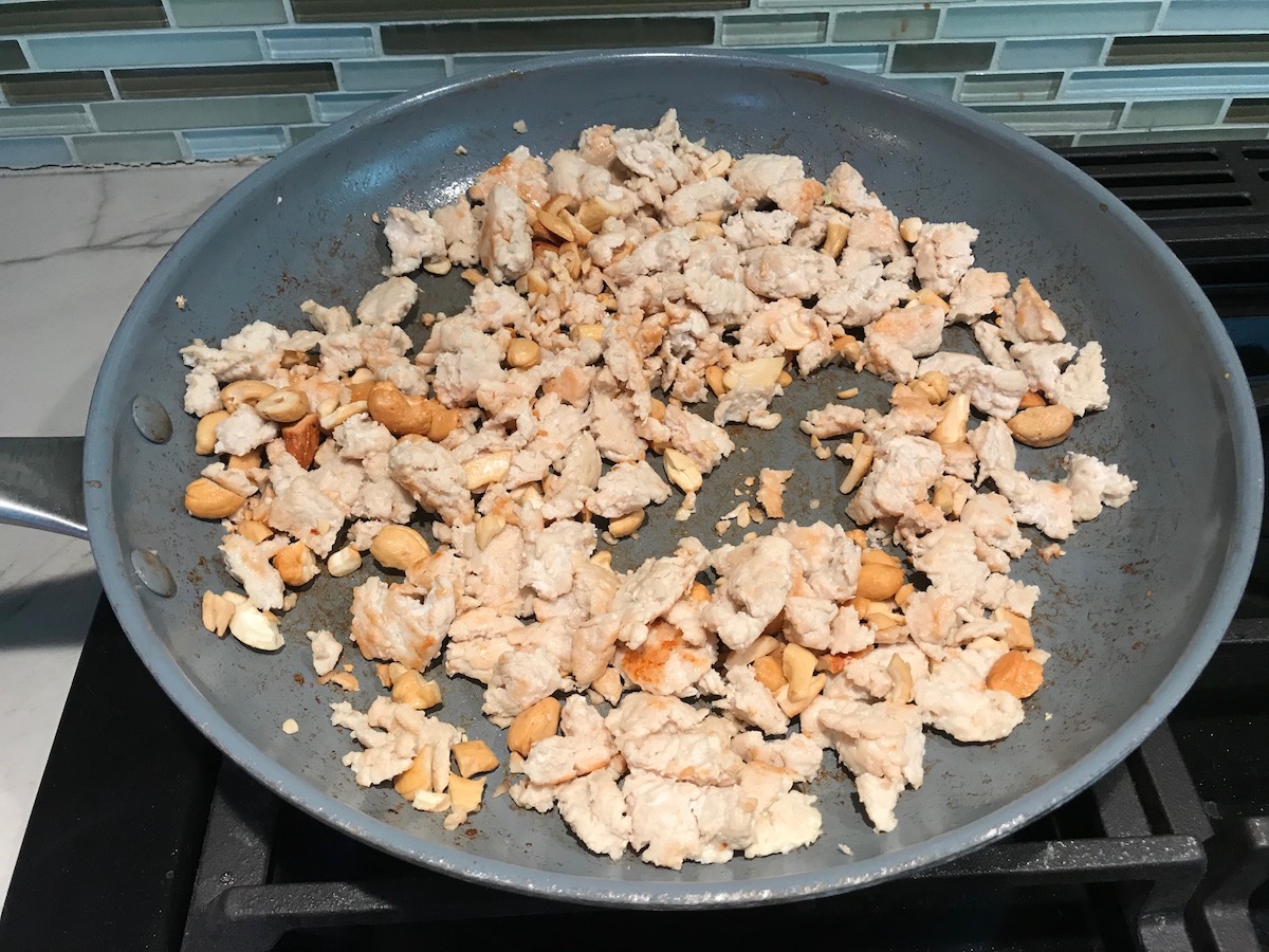 Ground chicken cooking in a pan for low carb Chicken Lettuce Wraps.