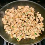 Ground Italian Chicken Sausage cooked in a frying pan..