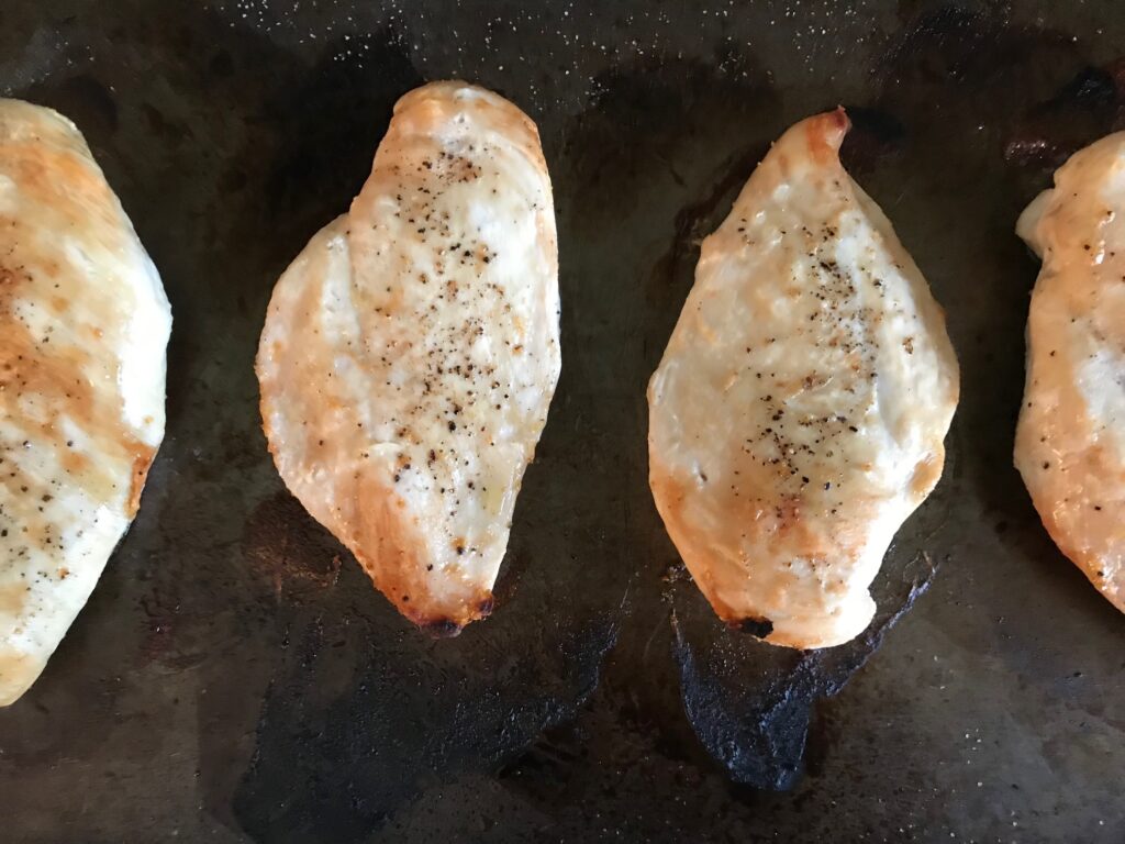 Cooked seasoned chicken breasts on a sheet pan to show options for storing chicken.