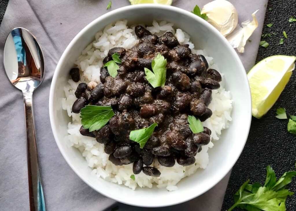 Cooked black beans over rice with cilantro garnish for post 'Can you freeze pulled pork'.