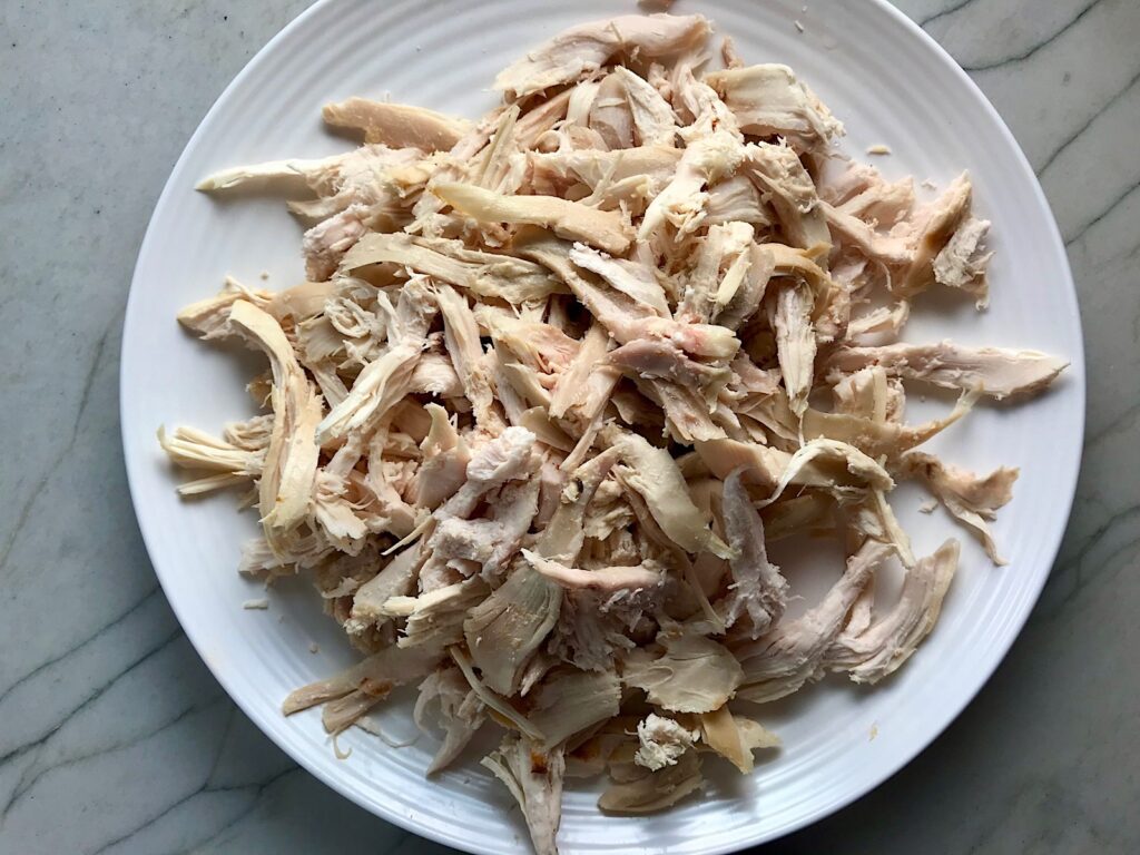 Cooked shredded chicken on a plate for post 'Can you freeze pulled pork'.