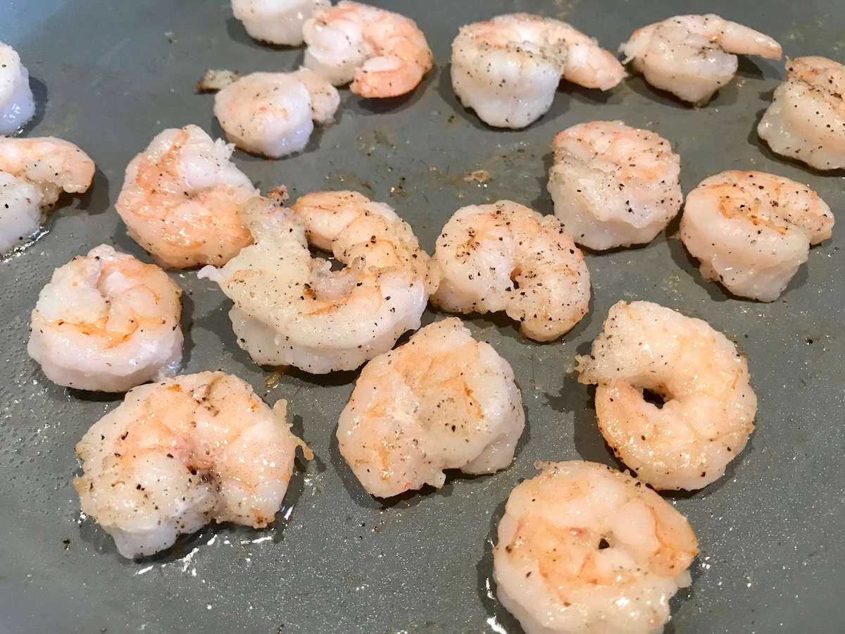 Shrimp searing in pan for Creamy Chinese Coconut Shrimp Recipe. It's filled with flavor from garlic, ginger, coconut, and more. Done in under 30 minutes, it's perfect for busy nights!