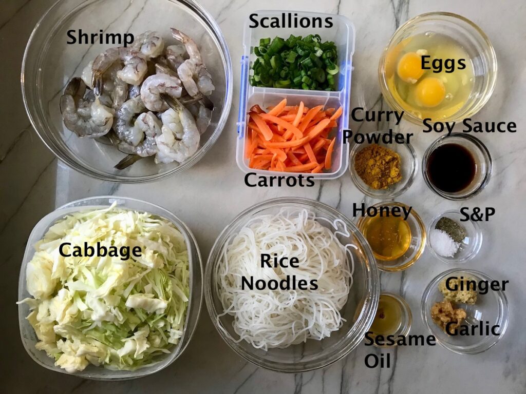 All ingredients chopped and measured uncooked in individual bowls on counter for Shrimp Mei Fun Recipe, Singapore Noodles. It's an easy stir fry to make at home and tastes so much better than take out! With carrots, bean sprouts, curry powder, sesame oil, and more it's is a 30 minute weeknight dinner.