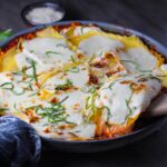 Angle shot of No-Bake Lasagna in skillet with spatula scooping a piece out. It cooks in a skillet or frying pan on the stovetop to save time!