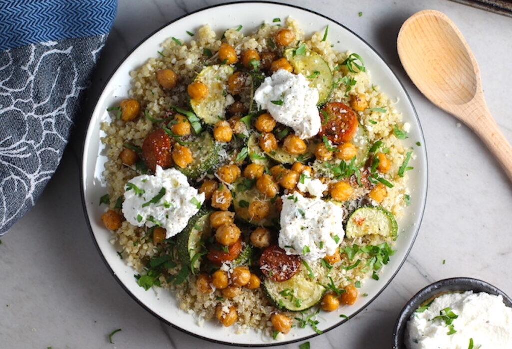 Easy Ricotta Filling recipe dolloped on top of a Mediterranean plate with quinoa, sausage, chickpeas, and zucchini.